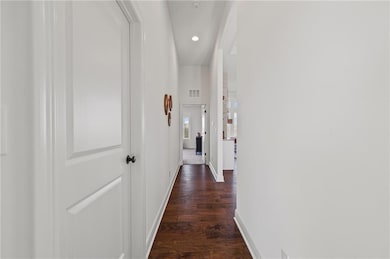 Corridor featuring engineered wood floors and recessed lighting