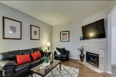 Living room with wood finished floors, a fireplace