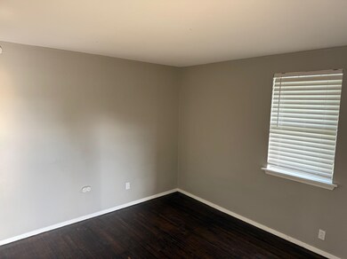 Empty room featuring baseboards and dark wood-style floors
