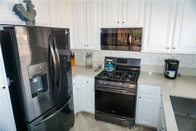 Kitchen with upgraded black stainless appliances, quartz counters, and over the range microwave.  Modern vinyl laminate flooring is upgraded throughout the home.