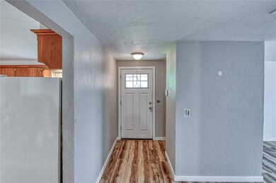 Entryway featuring a textured wall, light wood-style flooring, and a textured ceiling