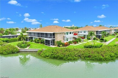 Back of house with a water view, a sunroom, and a yard