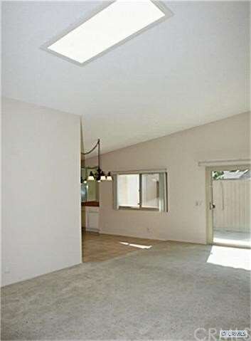 Light and bright living room has skylight in vault