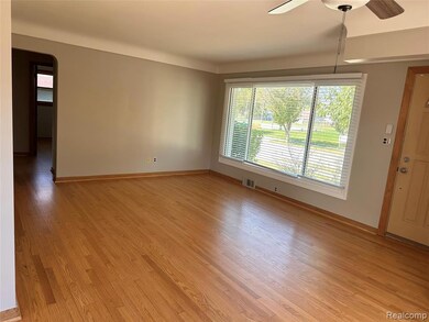 Spare room with arched walkways, light wood finished floors, and a ceiling fan