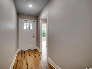 Entryway with baseboards, light wood-type flooring, and recessed lighting
