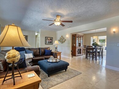 This spacious living room has newer windows, travertine floors, and opens to the diining room and the kitchen and to the sunroom beyond.  Great floor plan.  The kitchen is to the right of the dining room.