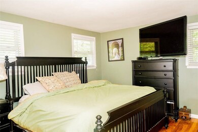 Bedroom featuring wood finished floors and baseboards