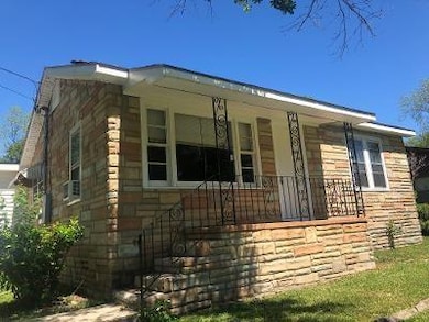 View of side of property featuring a porch and stone siding