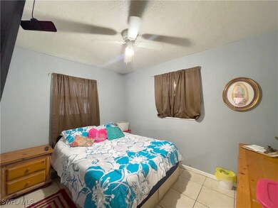 Tiled bedroom featuring a textured ceiling and cei