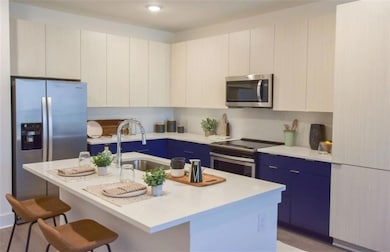 Kitchen featuring a kitchen island with sink, stai