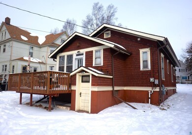 Snow covered back of property featuring a deck