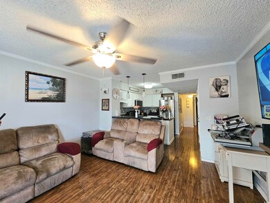 Living room with ornamental molding, dark hardwood