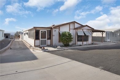 View of front of home featuring an attached carport and a sunroom.