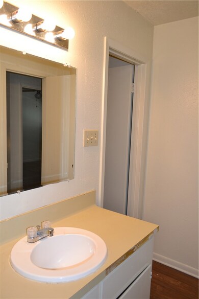 Bathroom featuring wood finished floors, vanity, and baseboards