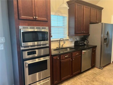 View of kitchen with granite and stainless steel appliances