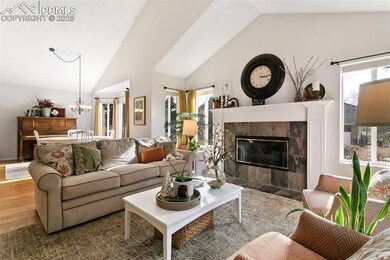 Living area featuring lofted ceiling, a tiled fire