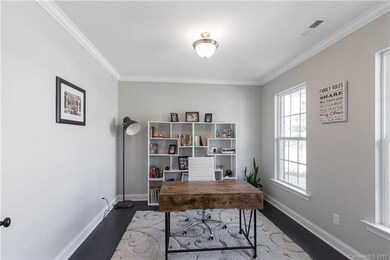 The office features french doors, crown mouldings 
