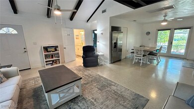 Living room with light speckled floor, visible ven