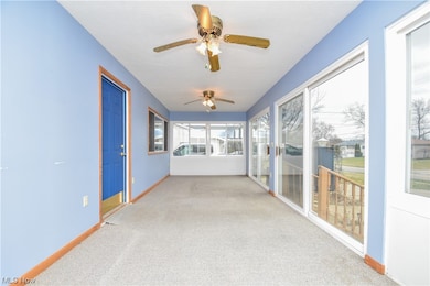 Unfurnished sunroom with ceiling fan