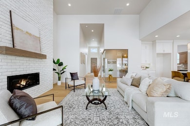 Living room featuring light wood-type flooring, recessed lighting, a towering ceiling, and a fireplace