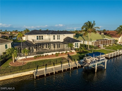 Back of property with a patio area, a water view, a balcony, and boat lift with tritoon included
