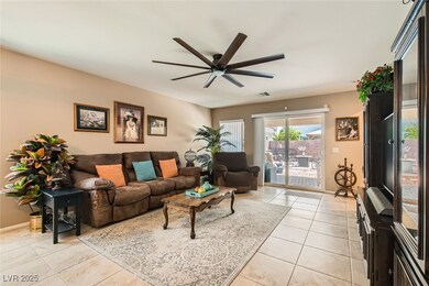 Living area featuring a ceiling fan and light tile