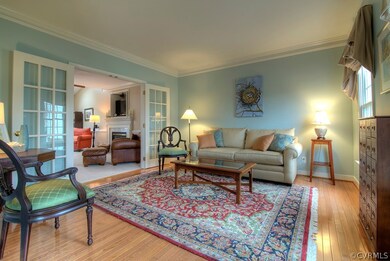 Living room with French doors, double member crown molding and hardwood floors.