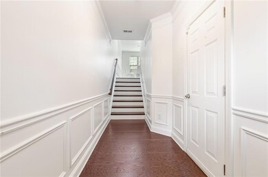Staircase featuring visible vents, a wainscoted wa