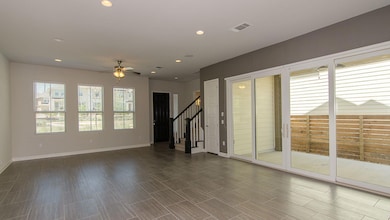 Unfurnished room featuring a ceiling fan, stairs,