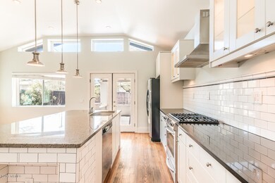 Kitchen with gas range and hood vent