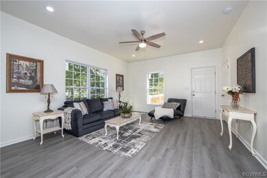 Hardwood floored living room featuring ceiling fan