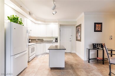 Kitchen featuring ornamental molding, white applia