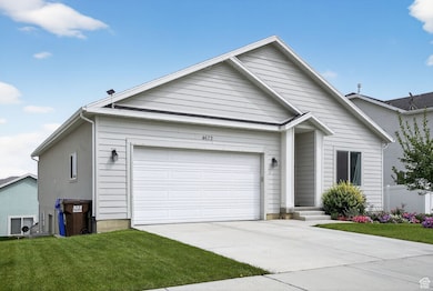 Ranch-style house featuring driveway, an attached garage, and a front yard