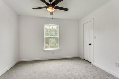 Carpeted empty room with ceiling fan