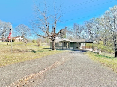 Single story home with a front lawn, aphalt drivew