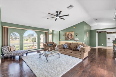 Living room featuring ceiling fan, dark hardwood /