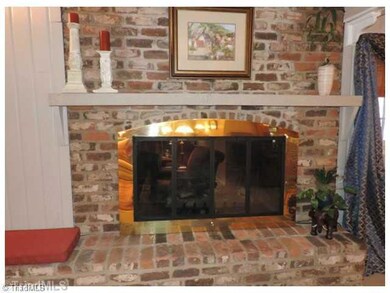 Remarks. Brick fireplace and hearth with custom made brass doors and screen