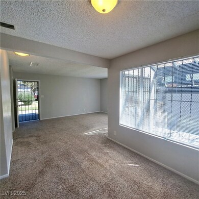 Unfurnished room with baseboards, a textured ceili