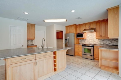 Kitchen with open shelves, appliances with stainl