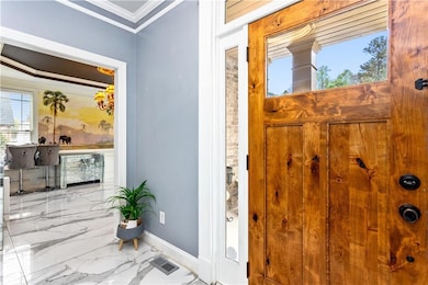 Entryway with crown molding, baseboards, visible v