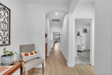The elegant, welcoming foyer opens into a sophisticated arched hallway featuring built in cabinetry, ideal for extra storage and laundry essentials.