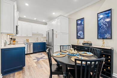 Dining space with crown molding, light wood finished floors, and recessed lighting