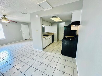 Kitchen with black appliances, a sink, a textured