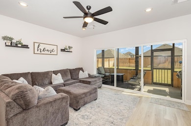Living room with ceiling fan, wood finished floor