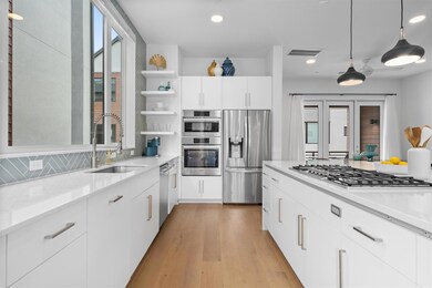 Kitchen with decorative backsplash, light wood fi