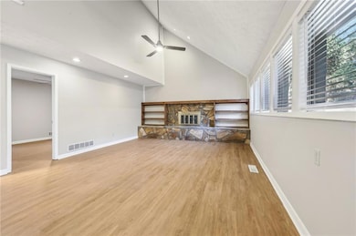 Unfurnished living room featuring ceiling fan, a f