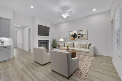 Living area with ceiling fan, light wood-type - VIRTUALLY STAGED flooring, a glass covered fireplace, and recessed lighting