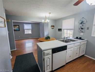 Kitchen featuring range, refrigerator, dishwasher, light vinyl flooring, white cabinetry