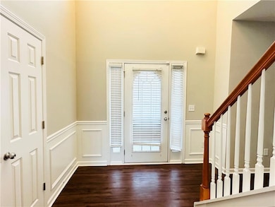 Foyer with a decorative wall, stairway, wainscotin