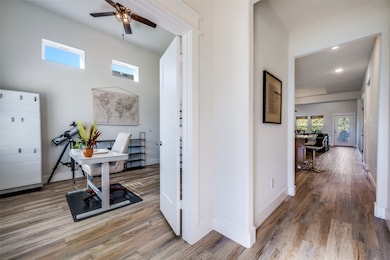 Office space featuring healthy amount of natural light, wood finished floors, and ceiling fan